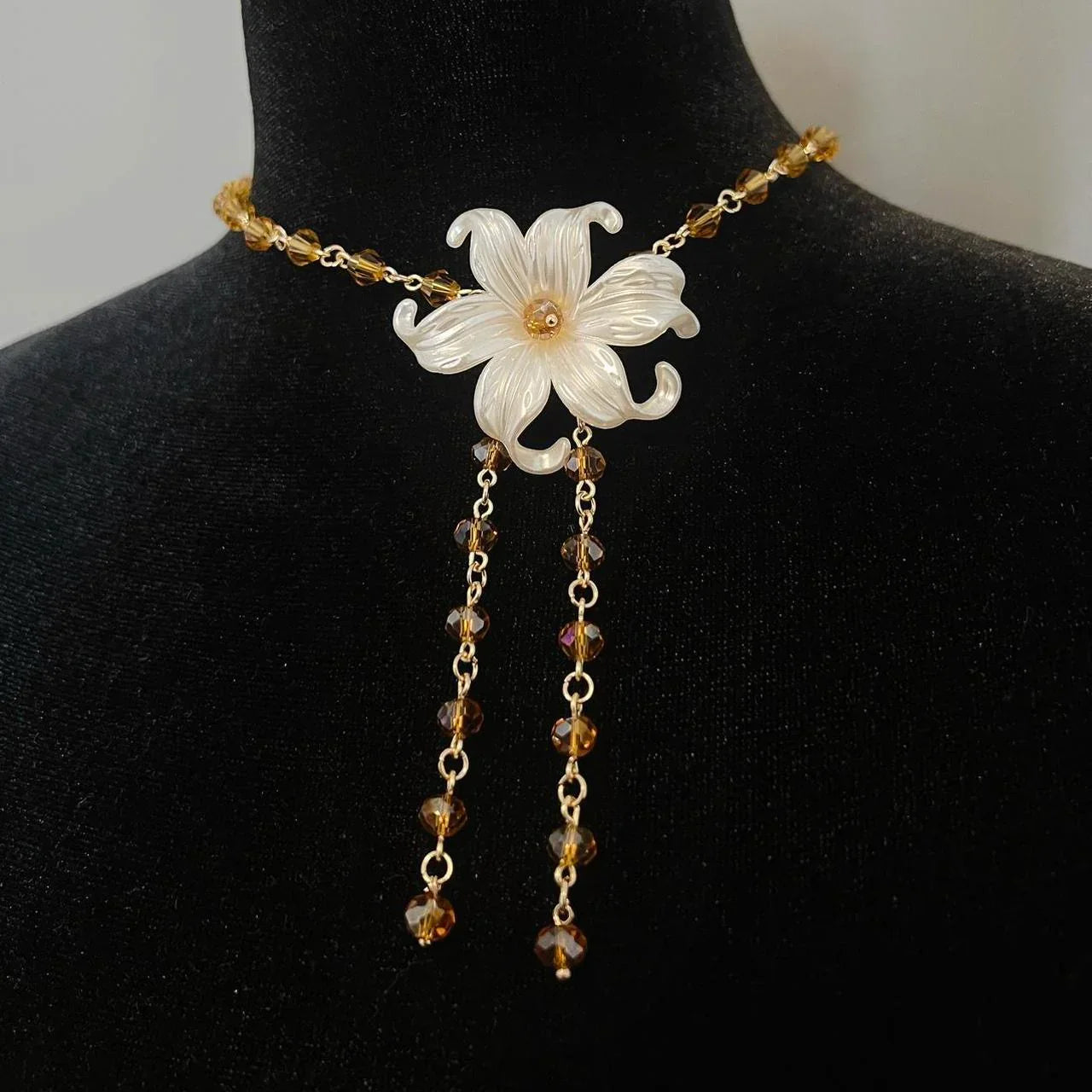 Elegant flower necklace with amber beads and dangling chains, perfect for handmade jewelry lovers.