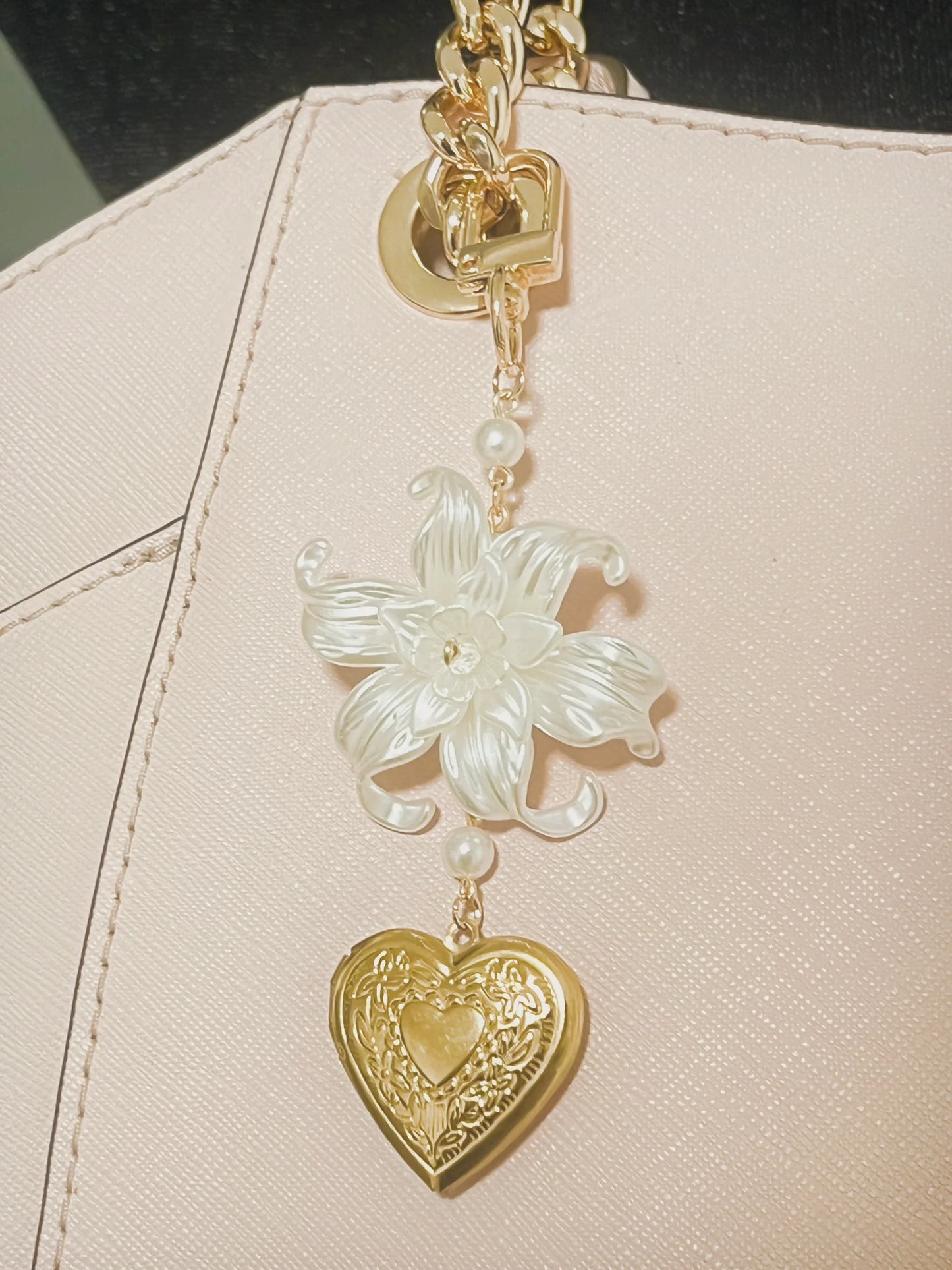 Elegant gold chain with white flower and heart locket charm, perfect handmade accessory for bags.
