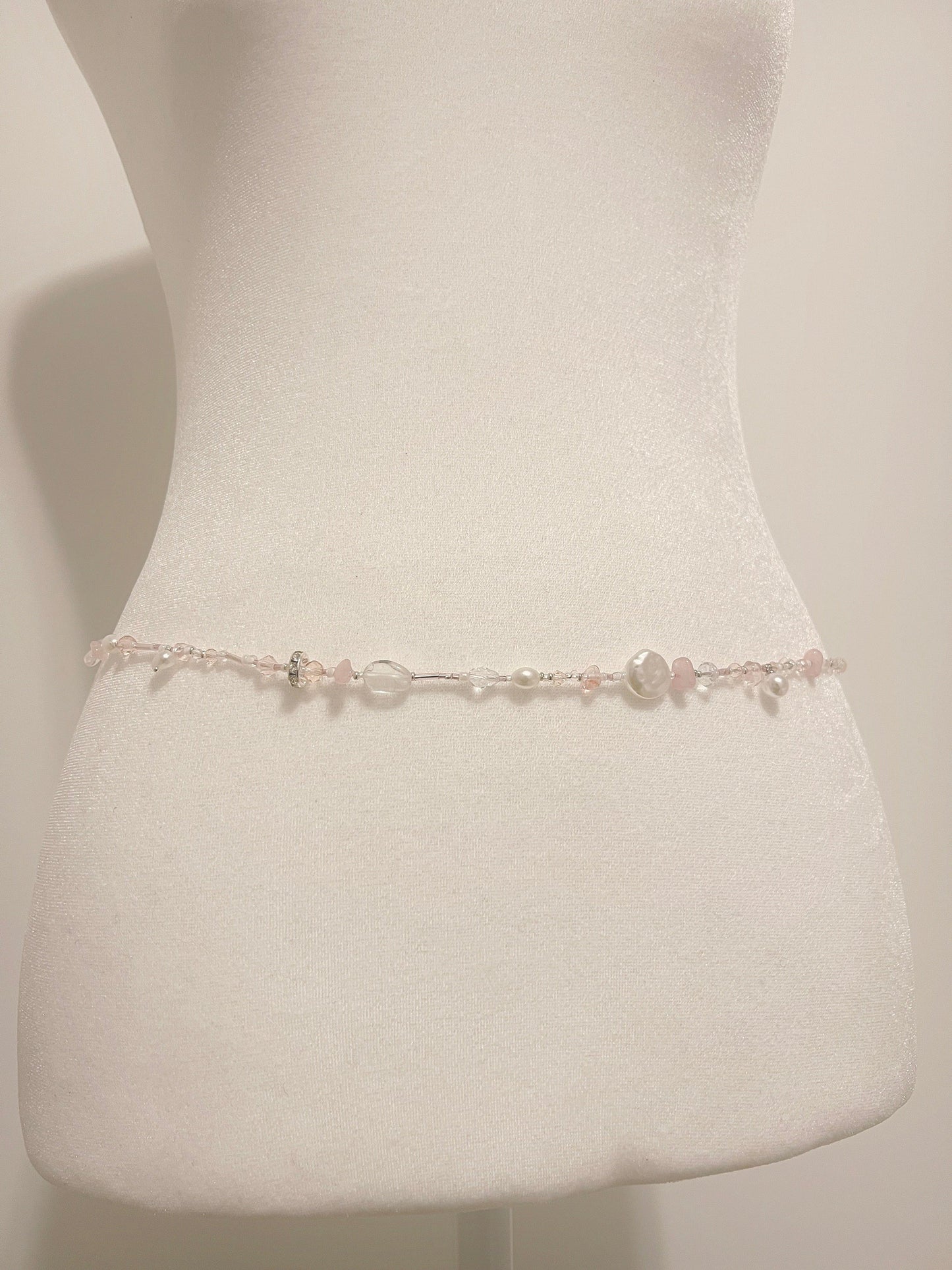 Delicate chelure waist bead with pink rose quartz, pearls, and crystal beads on a mannequin