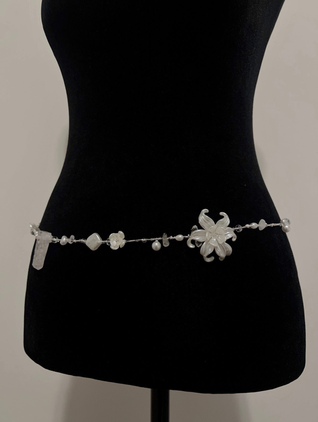 Elegant white floral waist bead with pearls and crystals on black mannequin