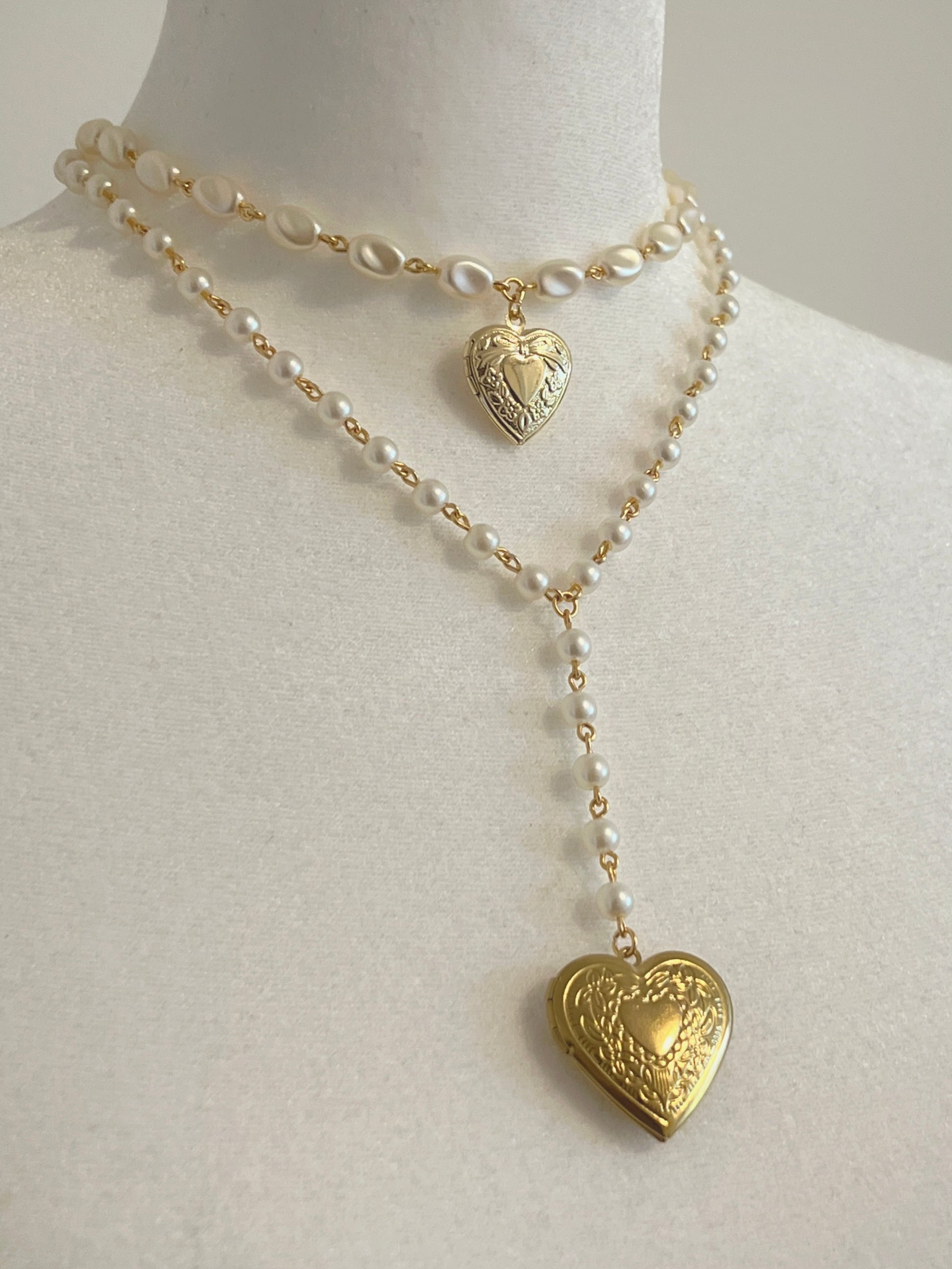 Elegant pearl necklace with gold heart lockets, perfect for handmade jewelry lovers.