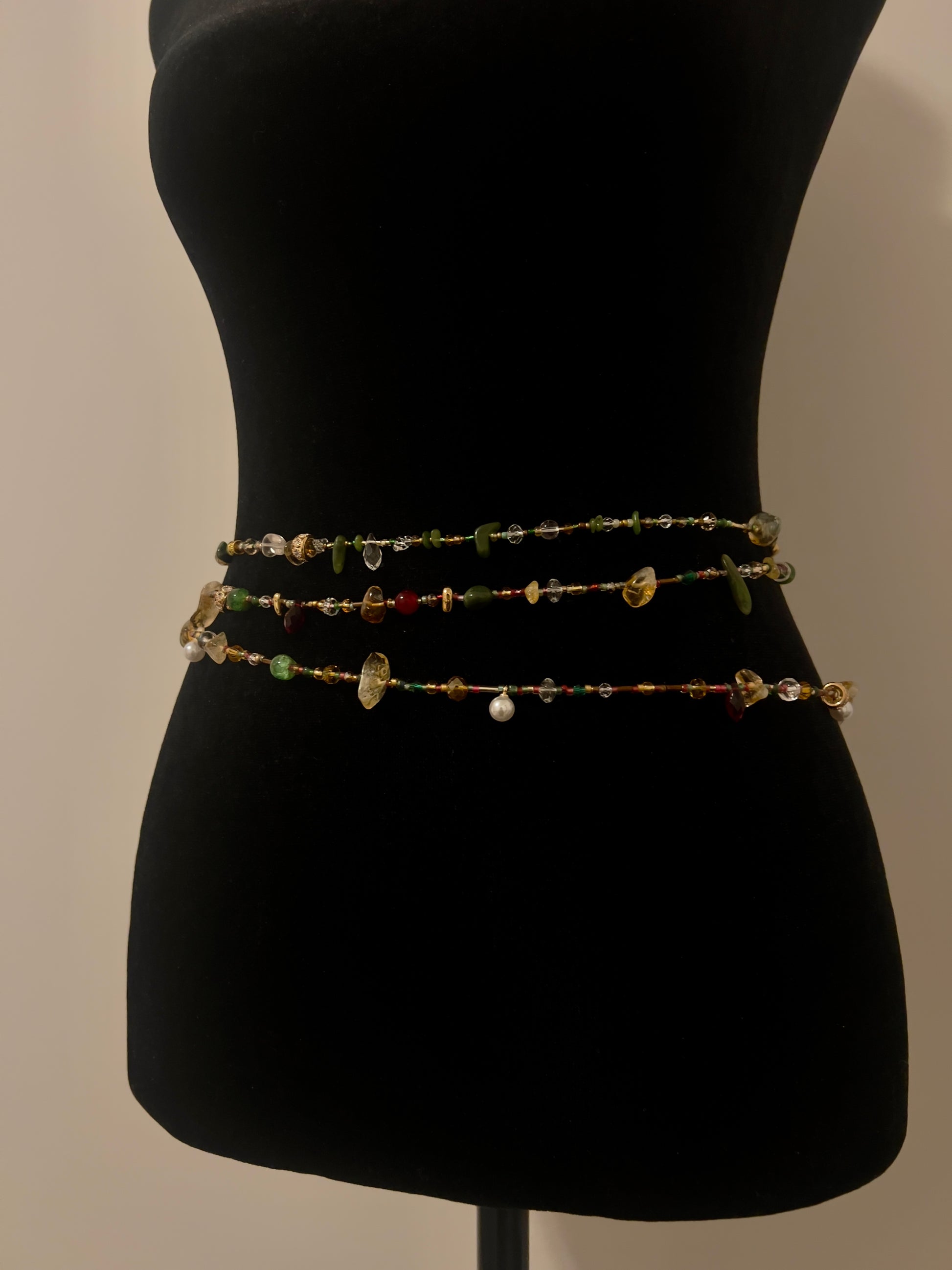 Handmade waist beads with colorful gemstones and pearls on black mannequin