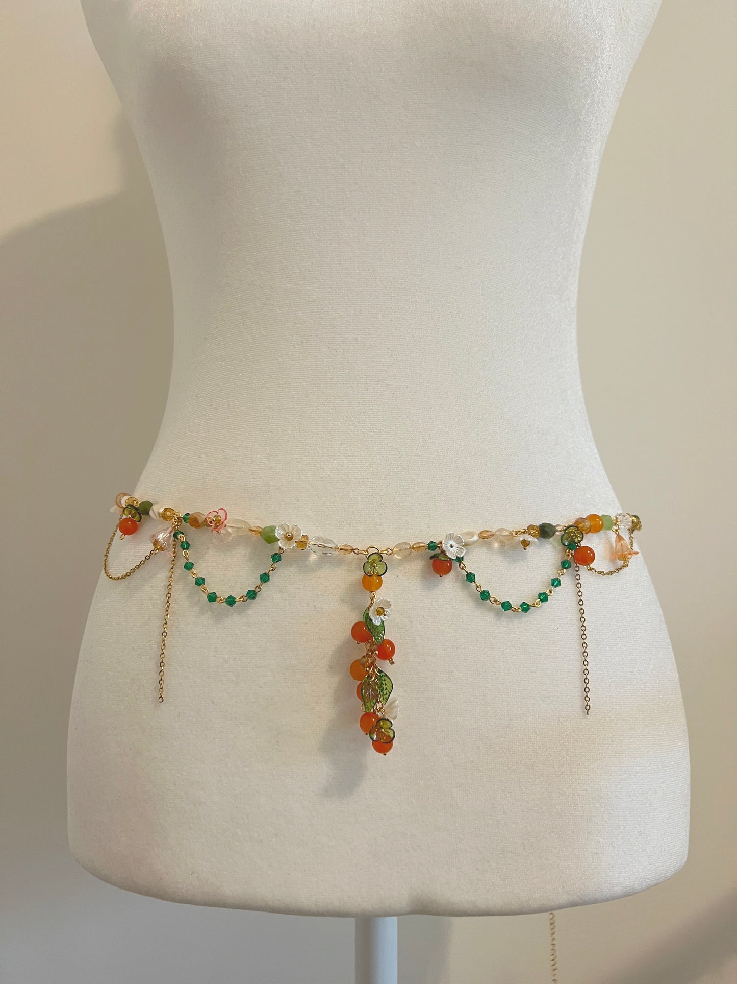Handmade floral waist bead with orange, green beads and gold chains, perfect for boho style.