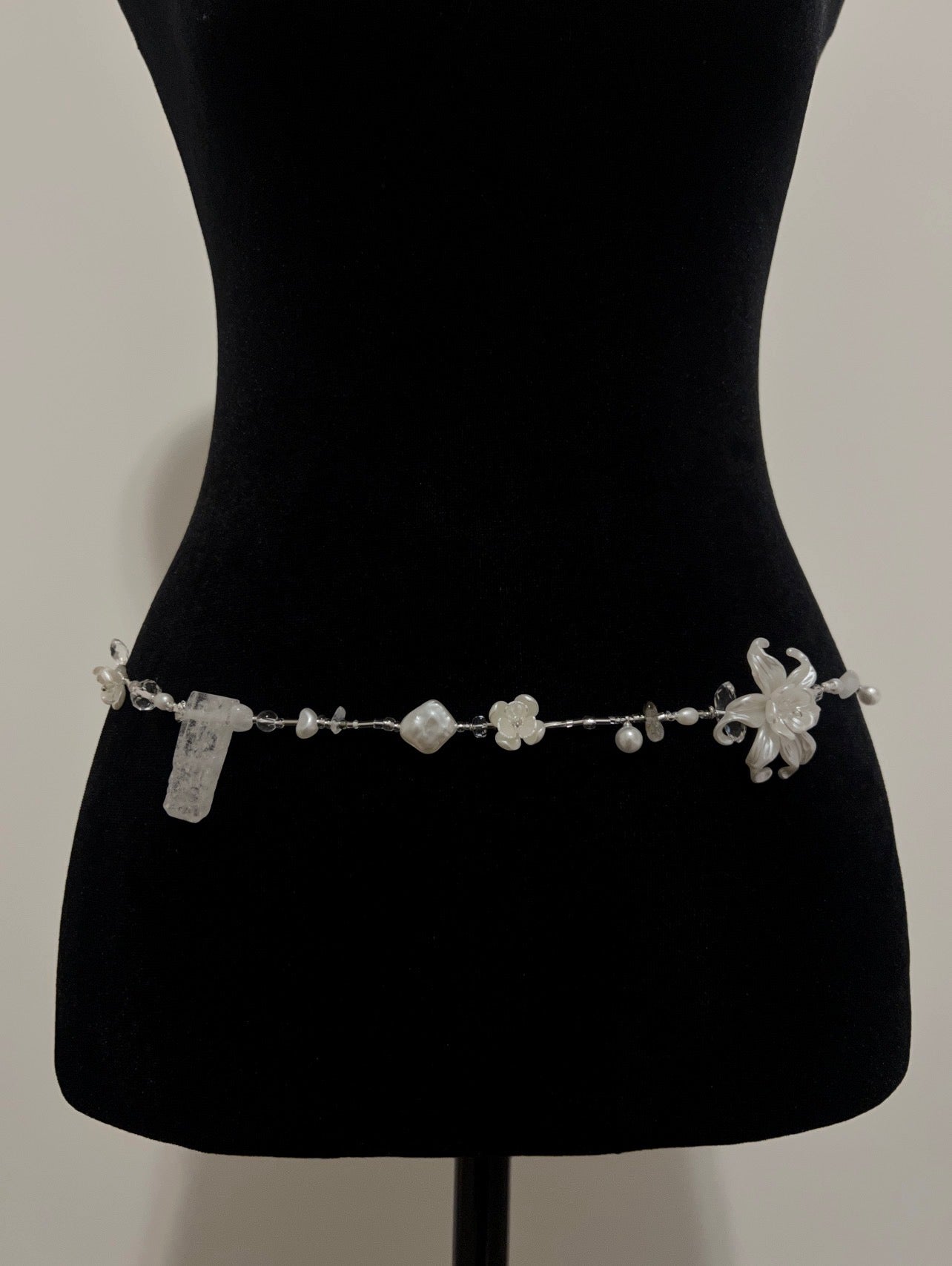 Elegant handmade waist bead with pearls and floral accents, perfect for accessorizing any outfit.